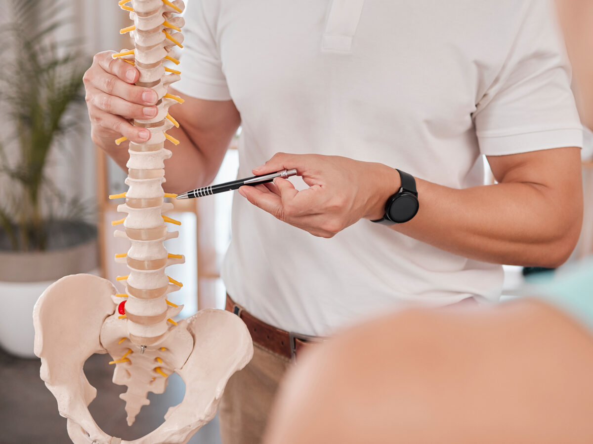 Doctor explaining a spine model to a patient — chiropractor and pain practice marketing Louisville KY